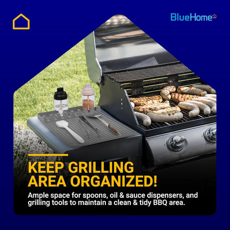 Grey silicone grill mat organizing BBQ tools and sauce dispensers on a side shelf next to a gas grill.