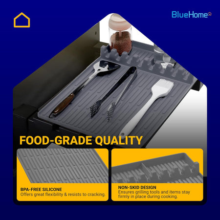 Grey silicone grill mat with slots for holding grilling utensils and seasoning jars.