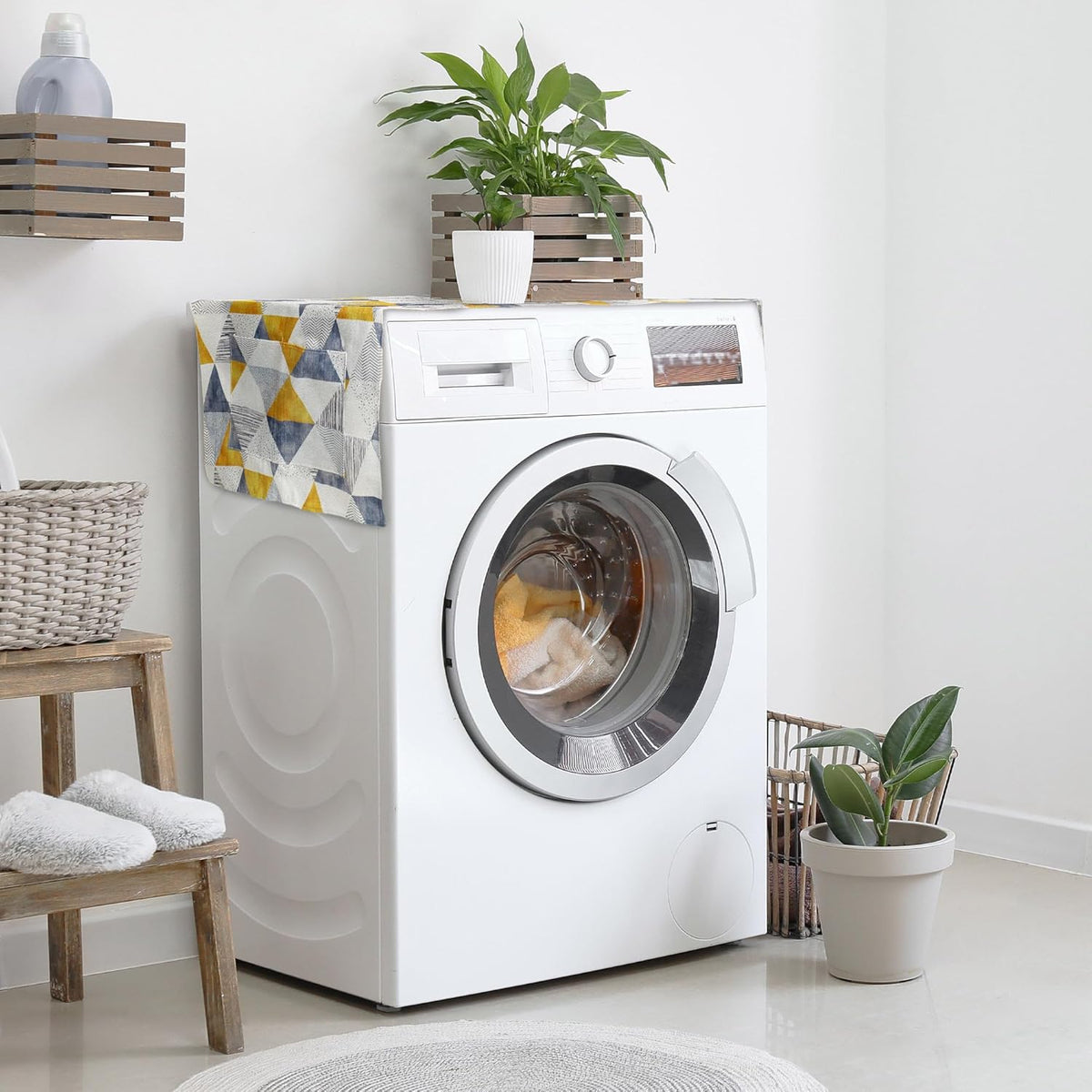 Geometric patterned washer and dryer top cover protector mat with side storage pockets on a white washing machine.