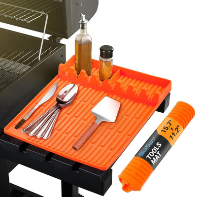 Orange silicone griddle mat holding grilling tools and condiments on a side shelf with a rolled mat shown separately.