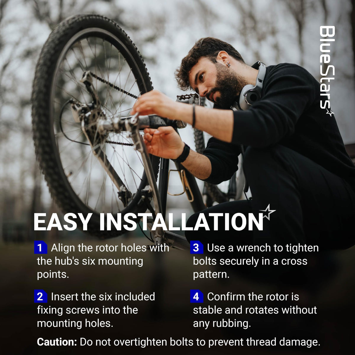 Cyclist installing a 180mm stainless steel disc brake rotor with 6 bolts using a wrench.