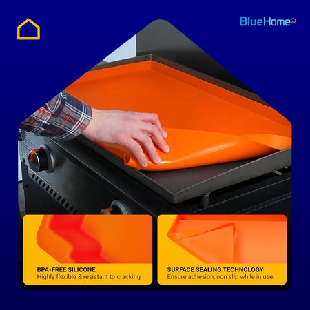 Hand placing an orange 28-inch silicone protective mat onto a Blackstone griddle surface.