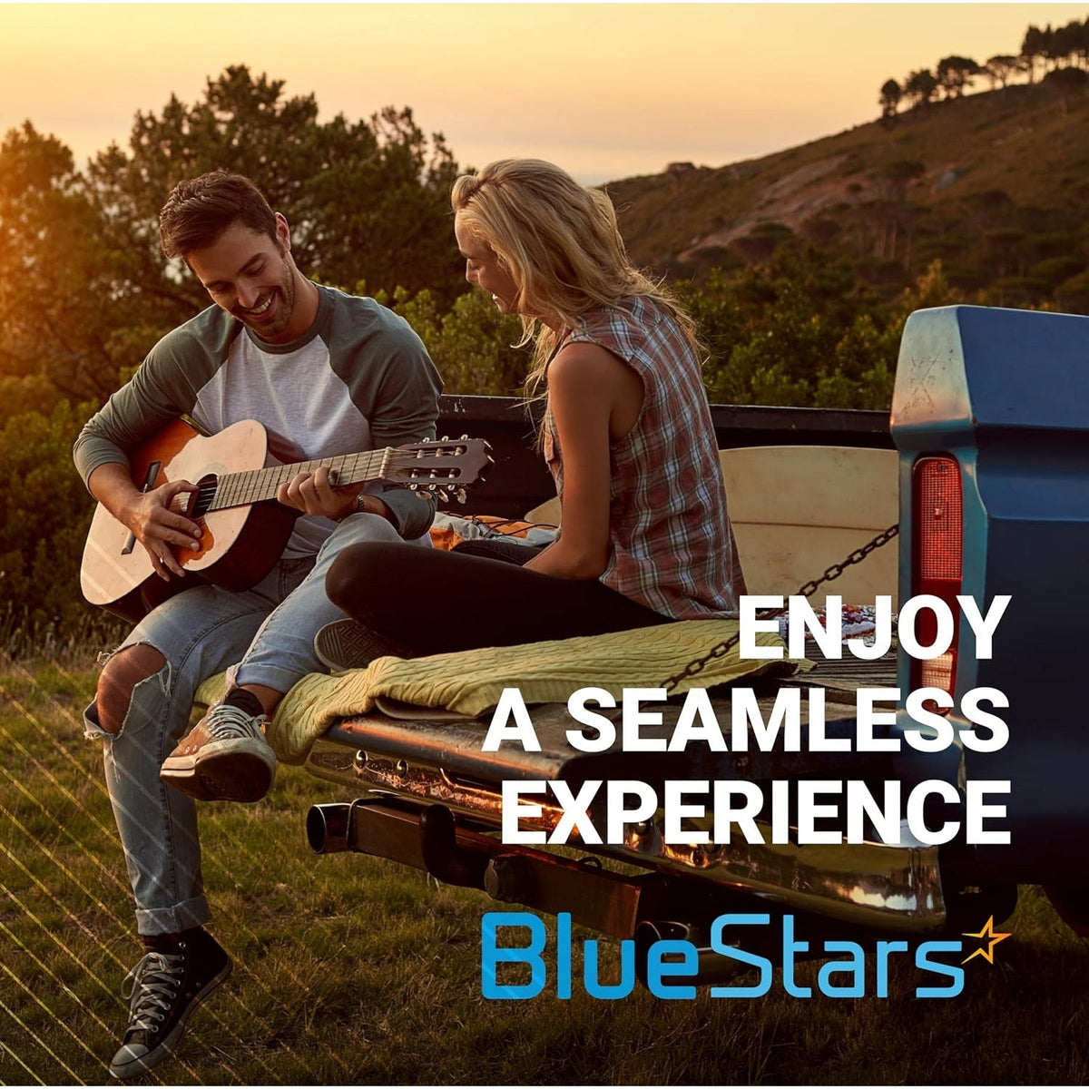 Couple sitting on the tailgate of a pickup truck playing guitar, promotional lifestyle image for BlueStars.