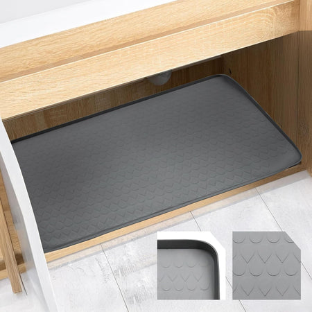 Grey 34" x 22" under sink mat with textured pattern installed inside a wooden kitchen cabinet.